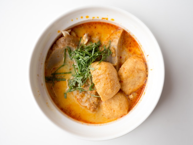 Photo laksa shrimp dumplings in white bowl on table.