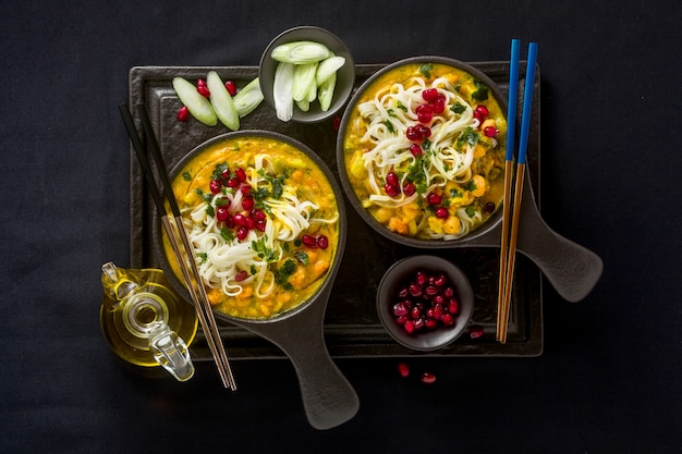 Laksa con zucca e latte di cocco, spaghetti di riso, broccoli e semi di melograno