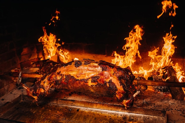 The lamb is cooked entirely on a spit on the fire Cooking