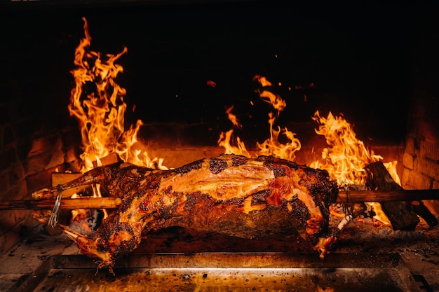 Photo the lamb is cooked entirely on a spit on the fire cooking