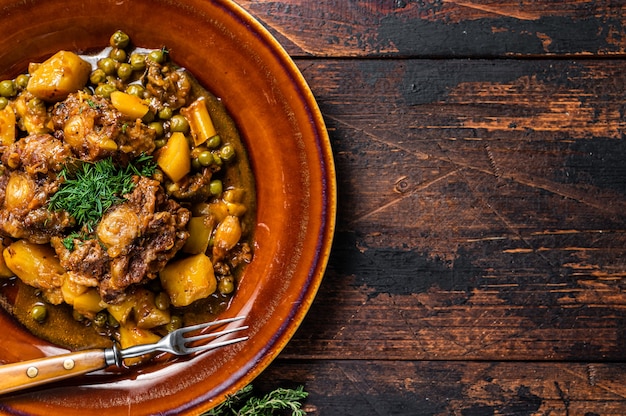 Lamb oxtails ragout with vegetables in a rustic plate