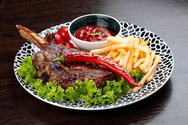 Lamb rack with fries and sauce On a wooden background