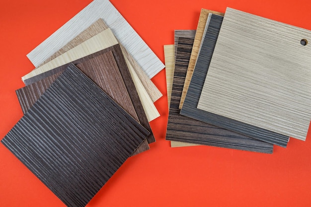 Laminaatplanken op een oranje achtergrond monsters van laminaat of parket met een patroon en textuur van hout voor vloeren en interieurontwerp productie van houten vloeren