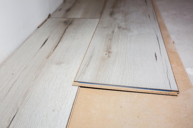 Laminate flooring in apartment Maintenance repair works renovation Restoration of wooden parquet planks indoors