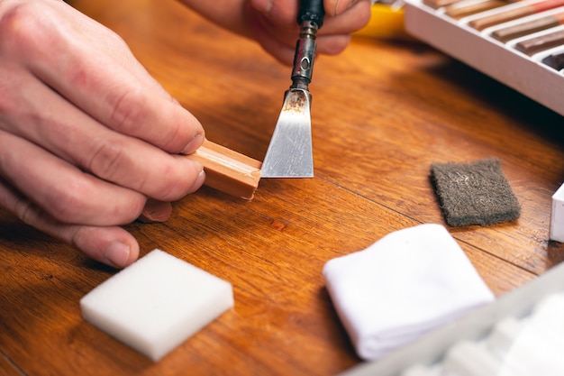 Laminate and parquet restoration wood repair tool kit wax pencils sealing scratches and chips close-up.