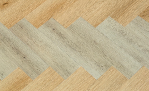 Laminate and parquet with herringbone background wooden floor\
with a chevron pattern in the living r...