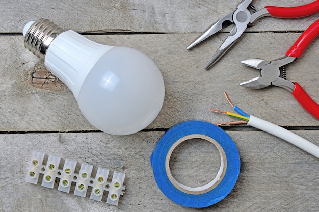 Lamp and electric tool on a wooden background. top view.