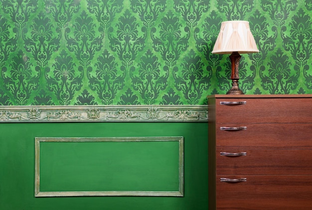 Лампа на мебели в зеленом винтажном интерьере. Богатый дом периода рококо. Интерьерная фотосессия