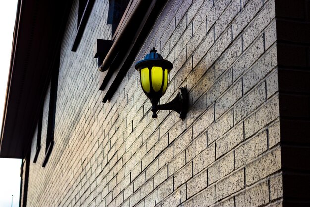 Foto lamp gemonteerd op een bakstenen muur die gouden licht verlicht
