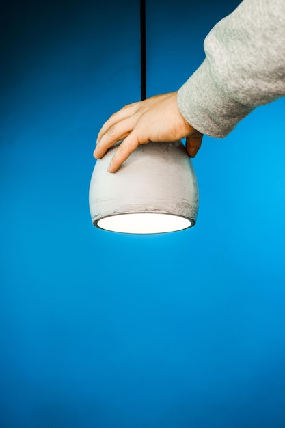 Lamp and hand on blue backround