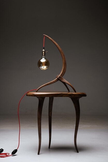 The lamp is curved out of wood and the table is made of\
wood