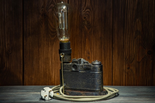 A lamp made of an old film camera on a wooden background