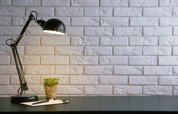 Lamp and plants on the desk on wall background