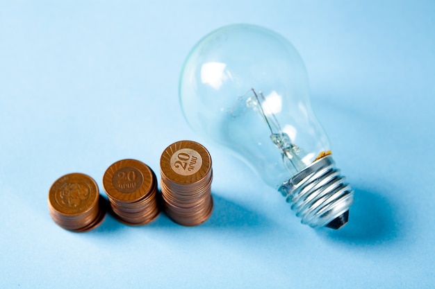 Lamp and set of coins in the form of a diagram on a blue surface