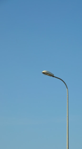 Lamp street lighting on the background of blue sky.