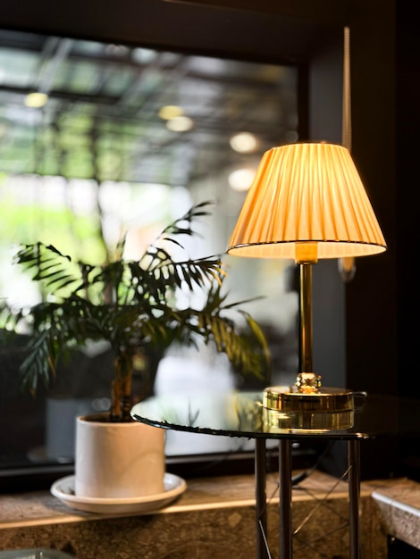 角に植物があるテーブル上のランプ