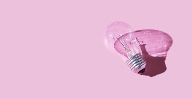 Foto lampada con ombra dura su sfondo rosa simbolo dell'idea creativa concetto di luce