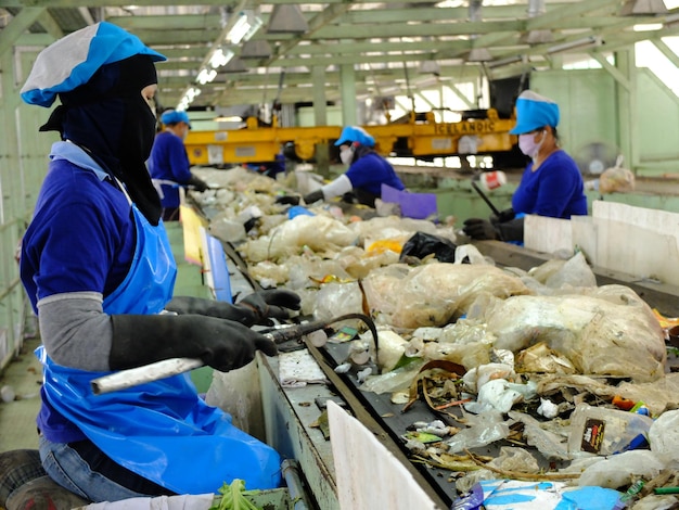 LAMPANGPROVINCE THAILANDDECEMBER 7 2016 Women in sepate line collect the plastic and metallic waste from household in waste disposal factory Recyclable waste in dump site