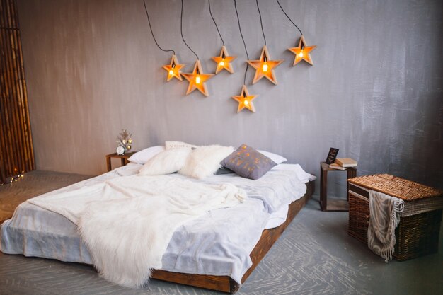 Lampen in de vorm van sterren hangen over een groot bed
