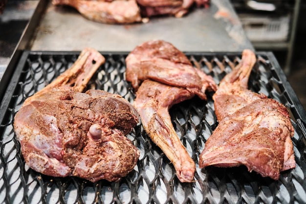 Lamsbout gekruid met kruiden op de grill klaar om te roken