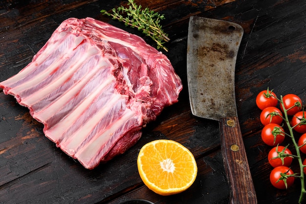 Lamsribben koken. Rauwe lamsrack set, op oude donkere houten tafel achtergrond