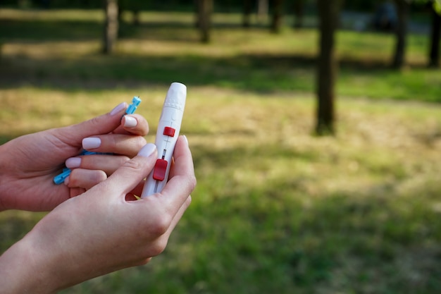 Lancet pen in the hands of a young woman on the street