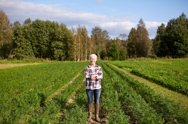 landbouw, tuinieren, landbouw en mensenconcept - gelukkige senior vrouw op de boerderij