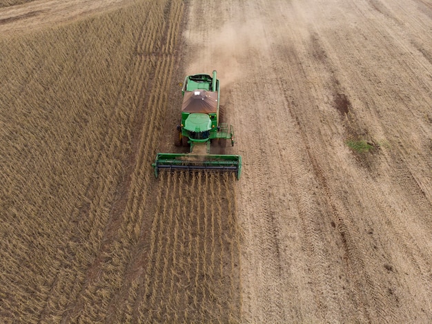 Landbouwtractor die sojabonen oogst in het veld.