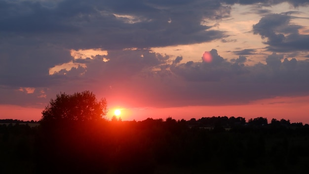 Landelijk landschap met veld bij zonsondergang en dorp op de achtergrond Vologda-regio