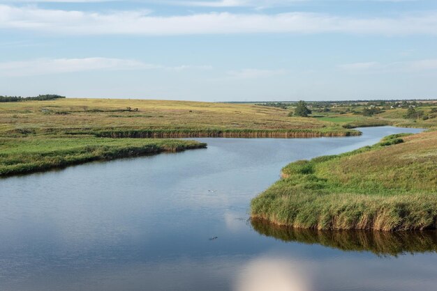 Landelijk landschap van een veld met een rivier op de achtergrond van een bewolkte hemel augustus, oekraïne