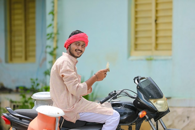 Landelijke scène: Indiase melkboer zit op de fiets en laat geld zien