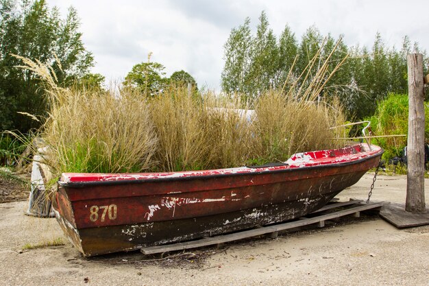 Landelijke scène met oude rode sjofele boot