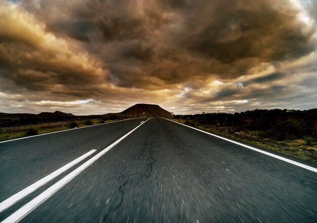Foto landelijke weg tegen bewolkte lucht