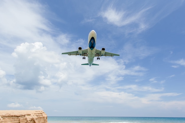 Foto atterraggio aereo sopra la spiaggia all'aeroporto di phuket. spiaggia di mai khao