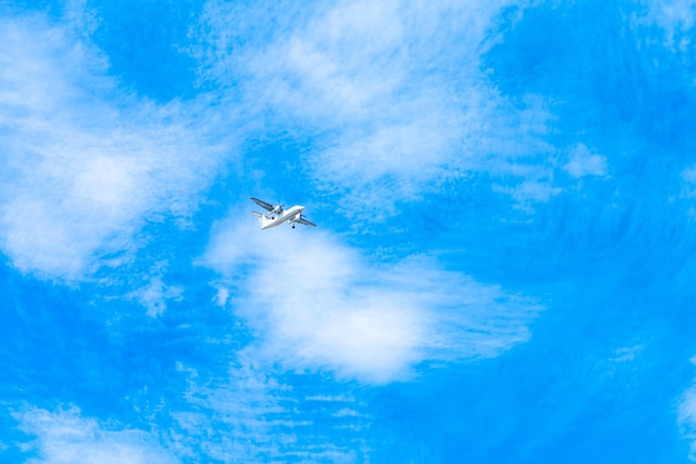 Landing plane on blue sky with clouds