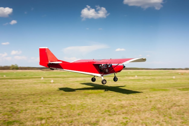 Landing van rode kleine privévliegtuigen op het vliegveld