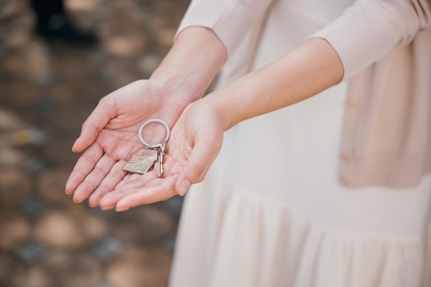 Landlords hand offers keys for a new home symbolizing investment and tenant happiness Real estate concept closeup signifies property deal success and security Give me