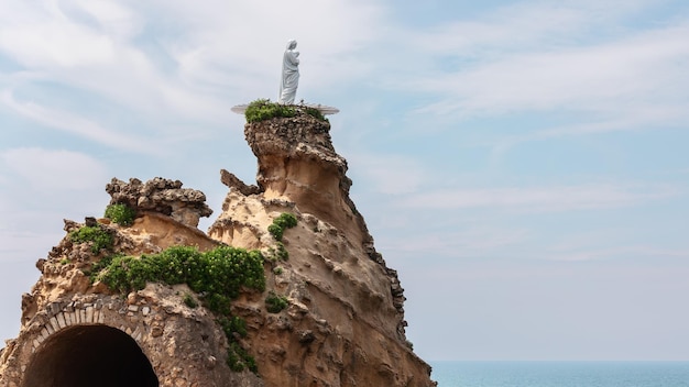 landmark of Biarritz city Rocher De La Vierge in shape of tongue with statue of Virgin Mary