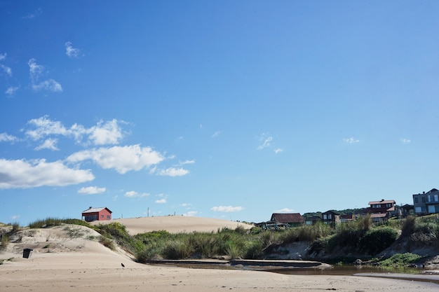 Landscape of beach house with sky and clouds.