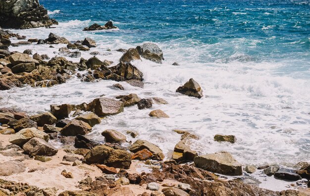 Landscape of a beach shore with waves and foam