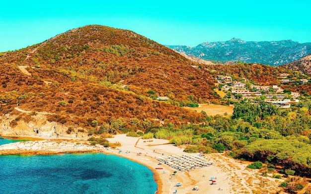 Il paesaggio della spiaggia di chia e delle acque blu del mar mediterraneo in provincia di cagliari nel sud della sardegna in italia. scenario e natura. tecnica mista.