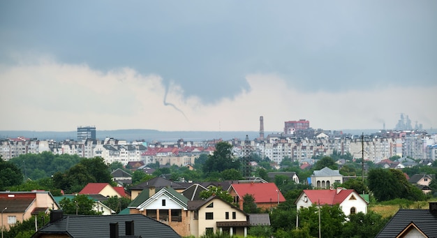 Landscape of dark clouds forming on stormy sky during\
thunderstorm over city rural area.