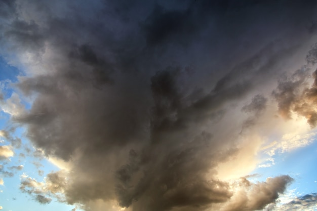 Landscape of dark clouds forming on stormy sky during thunderstorm.