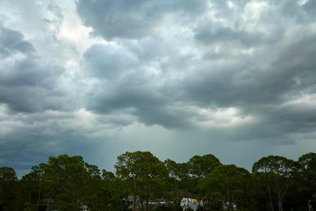 Landscape of dark ominous clouds forming on stormy sky before heavy thunderstorm over rural town area