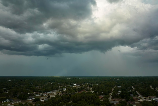 Landscape of dark ominous clouds forming on stormy sky before heavy thunderstorm over rural town area