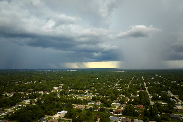 Landscape of dark ominous clouds forming on stormy sky during heavy thunderstorm over rural town area