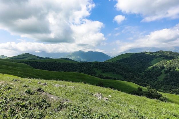 Пейзаж зеленого Актопракского перевала на Кавказской дороге и горах под серыми облаками КабардиноБалкария Россия