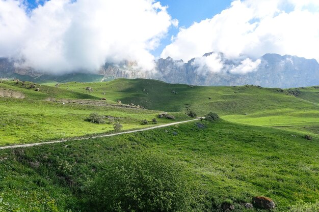 コーカサス道路の緑のAktoprak峠の風景と灰色の雲の下の山々KabardinoBalkariaロシア