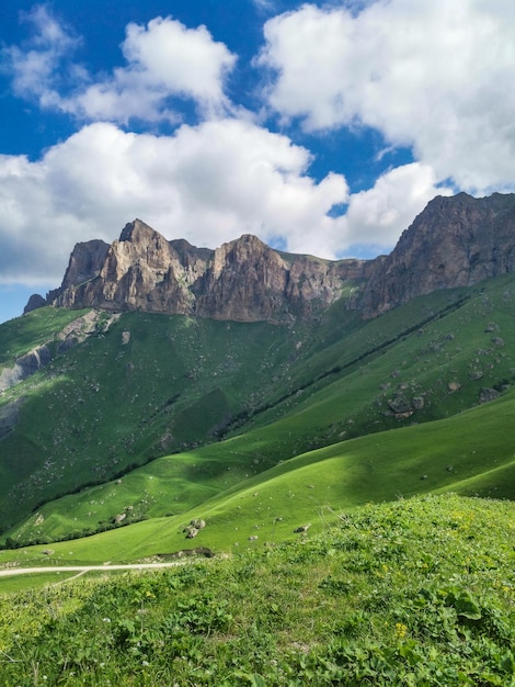 The landscape of the green Aktoprak pass in the Caucasus the road and the mountains under gray clouds Russia