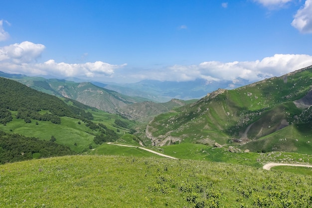 Пейзаж зеленого перевала Актопрак на Кавказской дороге и горы под серыми облаками